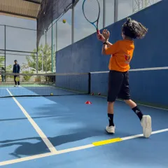 A young player executes a forehand on our blue hard court. Our programs focus on teaching proper technique and form from an early age, setting the stage for future development and competitive success.