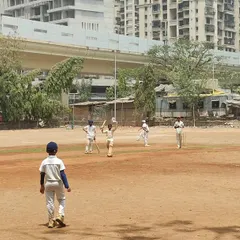 A young wicketkeeper batsman holds his ground during a competitive match. We train our players to build long innings and develop the temperament needed for real match situations.