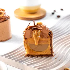 A cross-section of a hazelnut mousse dessert, revealing the gooey, multi-layered interior. This detailed shot is designed to make the viewer crave the rich combination of flavors and textures inside.