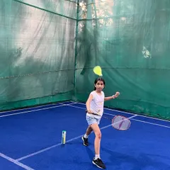 Watch her go. A young player practices her forehand shot on our indoor badminton court. Our coaching focuses on building solid fundamentals and confidence from an early age.