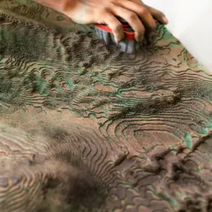 Craftsmanship is at the heart of our work. Here, an artisan meticulously refines the surface of the sculptural mountain wall for the Soaltee lobby. This hands-on process ensures every detail aligns with our vision of bringing the texture of the landscape indoors.