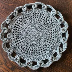 A top-down view of the grey lacy doily, showing the detailed stitch work and beautiful pattern.