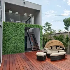 I love mixing materials to create a modern look. Here, I used a lush vertical garden wall to contrast with the warm wooden deck, creating a stylish outdoor lounge area. This is a great way to add greenery without losing floor space.