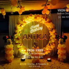 This outdoor Minnie Mouse setup for a fifth birthday uses a warm color palette of orange and yellow. The large balloon ring and character pillars create a fantastic focal point for an evening celebration.