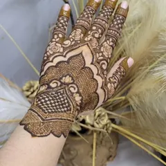 A single hand showcasing a dense party henna design. I combined a checkerboard pattern with delicate floral work and detailed finger designs for a complete and striking look.