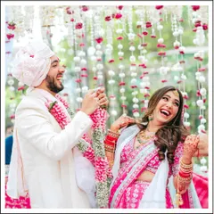 A moment of pure laughter and joy during the Varmala ceremony, showcasing the fun and playful side of the couple's relationship.