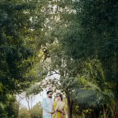 A serene portrait of the couple standing together amidst lush greenery. We use natural landscapes to create a beautiful and tranquil setting for your photos.