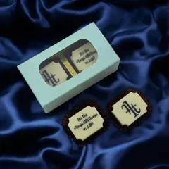 Make your brand a treat to remember with custom logo chocolates. These bespoke white chocolates, featuring a brand's monogram and motto, are perfect for corporate events, client appreciation, and marketing campaigns.