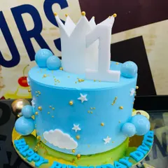 A royal blue 2kg cake for a first birthday, topped with a number one and a crown.