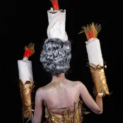 The back view of the candle-inspired look, showing the intricate hair updo designed to look like a melting candle and the glitter details on the back.