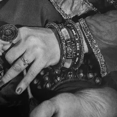 Another detail shot, this time showing the hand, foot, and traditional jewelry. Capturing the texture of the fabric, the metallic shine of the bangles, and the gesture of the hand is key to the story.