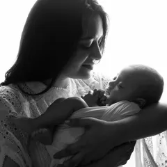 A mother's love captured in a delicate black and white silhouette. This style of photography creates a timeless and emotional portrait with your newborn.