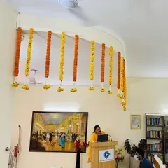 For corporate events like seminars or conferences, I create simple yet elegant ceiling decorations. These vertical flower strings of fresh marigolds hang above the main stage or podium area, adding a special touch without being distracting.