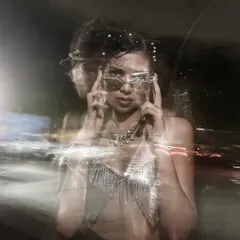 An experimental portrait using a slow shutter speed and camera movement to create a ghostly, energetic light trail effect. This is pure visual art.
