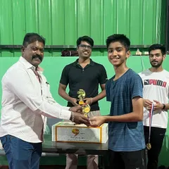 A young champion receives his trophy at our in-house league tournament. My events cater to various age groups, ensuring fair and exciting competition for all players, which is crucial for player development.