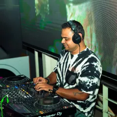 A candid shot of me at work, mixing tracks with the VJ screen in the background. This captures the dual role of being both a DJ and a VJ during a set.