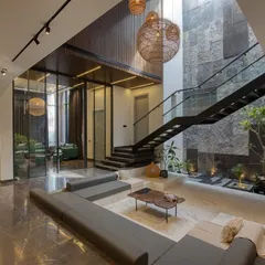 The heart of our Casa Acentuada project is this double-height sunken living area. We designed this space to be a central hub, connecting different levels of the home while drawing in abundant natural light through the skylight, creating a sense of openness and tranquility.