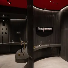 The interior of the FIMA store, where products are displayed like art in a museum. The curved counters and dark, slatted walls create distinct zones, allowing customers to explore different collections in a thoughtfully designed sequence.