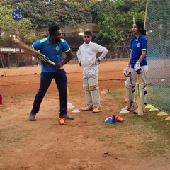 Personal attention is key to development. Here, a coach provides one-on-one batting stance correction to young male and female cricketers, ensuring they build a strong technical foundation from the start.