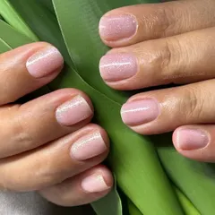 A beautiful example of BIAB nails with a stunning glitter topcoat. This technique provides a flawless, chip-free finish that strengthens weak nails and adds a touch of subtle shimmer.