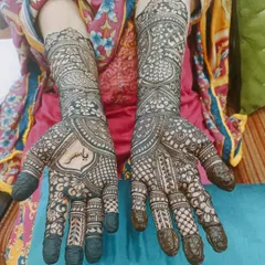 This full-coverage design has a personal touch, with the name 'Yasir' elegantly written in the center of the palm. The dark, fresh henna paste ensures the name will be a prominent feature as the stain develops.