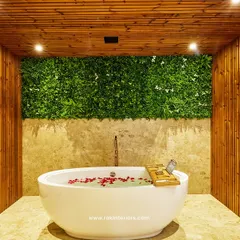 I designed this spa-like bathroom to be an escape for hotel guests. It features a freestanding tub, full-height wood-paneled walls, and a green wall accent to bring a touch of nature indoors, creating a serene and luxurious feel.