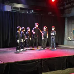 A group of young mimes getting ready for their scene. Our workshops teach children how to use their bodies to tell stories, building confidence and creative expression in a fun, supportive environment.