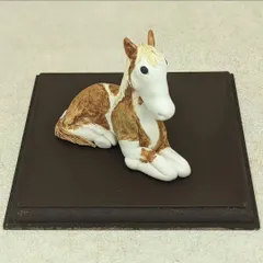 A handcrafted horse sculpture, made to be part of a larger birthday cake topper. I loved the challenge of creating this palm-sized animal, focusing on its gentle expression and coloring.