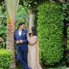 A romantic pre-wedding portrait in a lush garden setting. The couple's pose is natural and intimate, reflecting their connection.