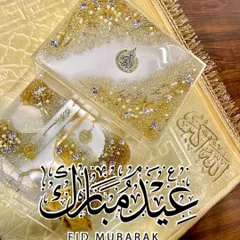 An elegant gift set in white and gold, perfect for Eid or any special occasion. This set includes a resin Quran box, a matching bookmark, and other accessories, all embellished with crystals and pearls for a luxurious finish.