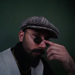 Adjusting the sunglasses in this shot adds a bit of character. It's a great example of a subtle, natural pose for a men's accessory or portrait photoshoot.