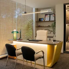 Another principal architect's cabin, this one featuring a custom desk with a curved, mustard-yellow base. The design is clean and minimal, with ample natural light and carefully selected decor to reflect personal style.