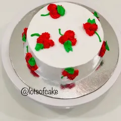 A simple and elegant design using whipped cream. In my workshops, I teach easy piping techniques to create beautiful patterns like these red rosettes on a classic white cake.