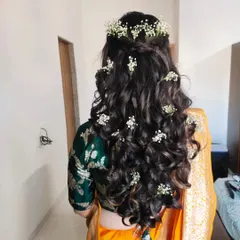 A hairstyle can make all the difference. For this Haldi look, I created soft, open curls and decorated them with delicate baby's breath flowers for a fresh and romantic feel.
