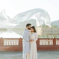 A moment of pure cinematic romance at Jal Mahal. The flowing white fabric catches the light beautifully, creating a dreamy and ethereal image against the serene lake palace.