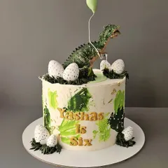 A roar-some 6th birthday for Yashas with this dinosaur cake. Featuring a realistic T-Rex, edible dinosaur eggs, and green buttercream details, it's a perfect cake for any dino enthusiast.