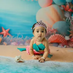 Capturing the crawling stage in a unique way. This little mermaid explores her sandy shore, creating a dynamic and adorable action shot.