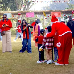 Santa Claus mingling with families at our Christmas event, with children gathering around him for photos.