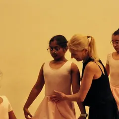 The foundation of ballet is built with careful guidance. Here, our Artistic Director Yana Lewis works with a young dancer, focusing on the precise posture and form that ensures safety and fosters growth from the very first step.