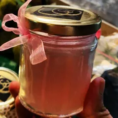 A finished custom jar candle, ready to be shipped to a happy customer. I hand-pour each one and can personalize everything from the scent and color of the wax to the label and the ribbon on the lid, making it a simple yet deeply personal gift.