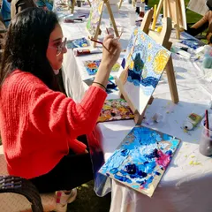 A participant engrossed in painting her version of 'Starry Night' at our outdoor art party.