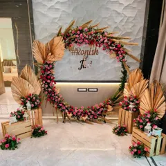 For a modern and personal touch, we design trendy photo backdrops like this circular arch. Combining rustic dried palms with vibrant pink roses and a custom hashtag, it becomes a favorite spot for guests to capture memories.