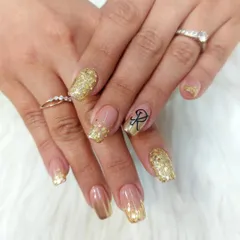 We offer personalized nail art, like adding a custom initial. This celebratory set features a cascade of gold glitter and a beautifully scripted initial, making it perfect for an engagement or anniversary.