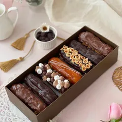 A box of seven of our finest eclairs, showcasing the variety of toppings and fillings we offer. Flavors include Classic, Rocher, Hazelnut, Caramel, and Blackforest.