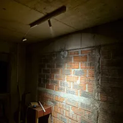 An on-site mock-up in a raw construction space. We use these tests to check the beam angle and intensity of our track lights against the actual surfaces, like this exposed brick wall, ensuring the final effect is exactly as planned.