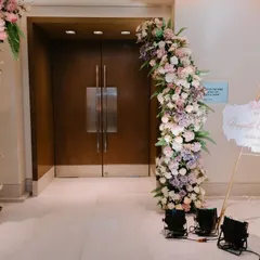 The entrance to the engagement ceremony, featuring a grand floral arch in pastel shades of pink, lavender, and white, creating a soft and romantic welcome.