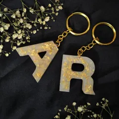 A matching set of 'A' and 'R' keychains in pearl white and gold flake. These are a popular choice for couples or best friends.