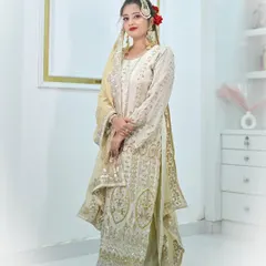 A stunning ivory sharara suit featuring heavy silver and gold embroidery. The matching embellished dupatta and traditional jewellery create a regal and elegant look.