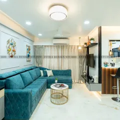 A look at a complete living room we designed, blending comfort and modern style. The vibrant teal L-shaped sofa, custom TV unit, and open-concept layout leading to the breakfast bar create a welcoming and cohesive family space.