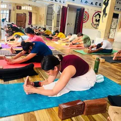 Students engage in Paschimottanasana (Seated Forward Bend). We use props like blocks to help everyone access the pose, regardless of their flexibility level.